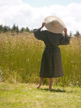 Load image into Gallery viewer, Woman seen from back wearing a brown kimono with white lines and large straw hat with summer field in background