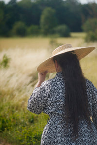Model with straw hat and long dark hair wearing black and white block printed kimono.
