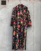 Load image into Gallery viewer, Colorful black floral-patterned dress hanging against a gray concrete wall