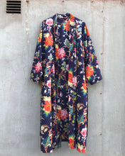 Load image into Gallery viewer, Colorful floral-patterned dark blue kimono hanging against a plain wall.