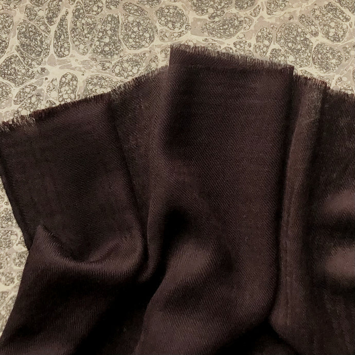 dark brown wool scarf on grey marble paper background