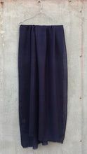 Load image into Gallery viewer, Dark blue scarf, hanging on a hanger against a concrete wall.