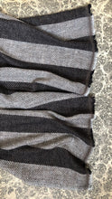Load image into Gallery viewer, A close-up of a striped woven wool scarf laid flat on a patterned surface, showing alternating dark brown and beige bands with frayed edges.