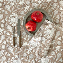 Load image into Gallery viewer, Block printed tablecloth and napkin with beige ground and white flowers. Two pomegranates on pewter plate.