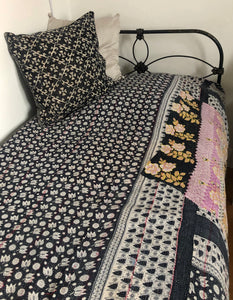 Bed with floral and geometric patterned bedding in black and white