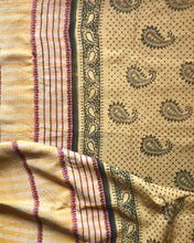 Load image into Gallery viewer, Close-up of a yellow vintage quilted fabric with paisley patterns and striped edges